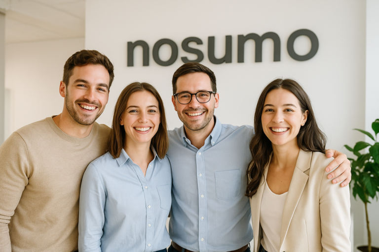 Team Nosumo in ufficio, cinque persone sorridenti davanti alla scritta aziendale.